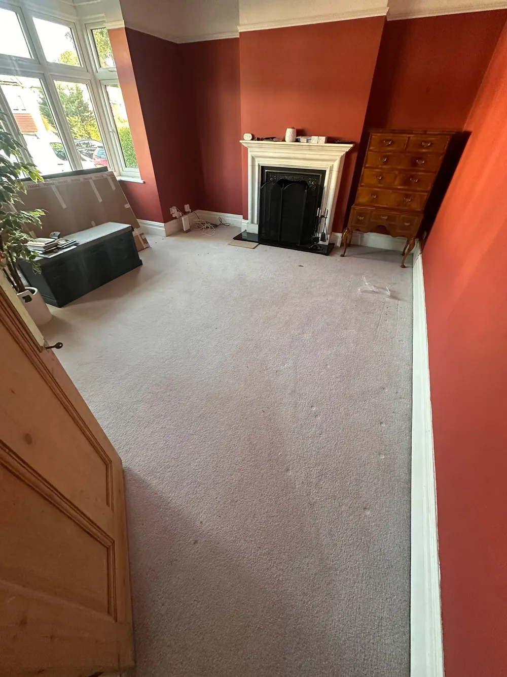 Lounge with red walls and fireplace showing the existing carpet before it was uplifted — South Croydon